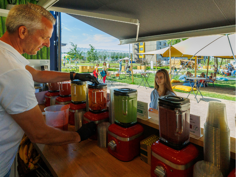 Student in front of a smoothie bar getting a fresh fruit smoothie